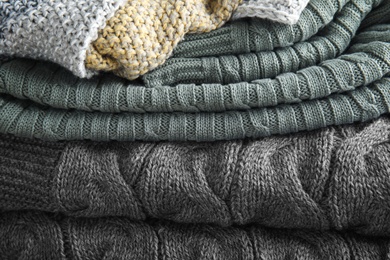 Photo of Stack of soft warm plaids as background, closeup