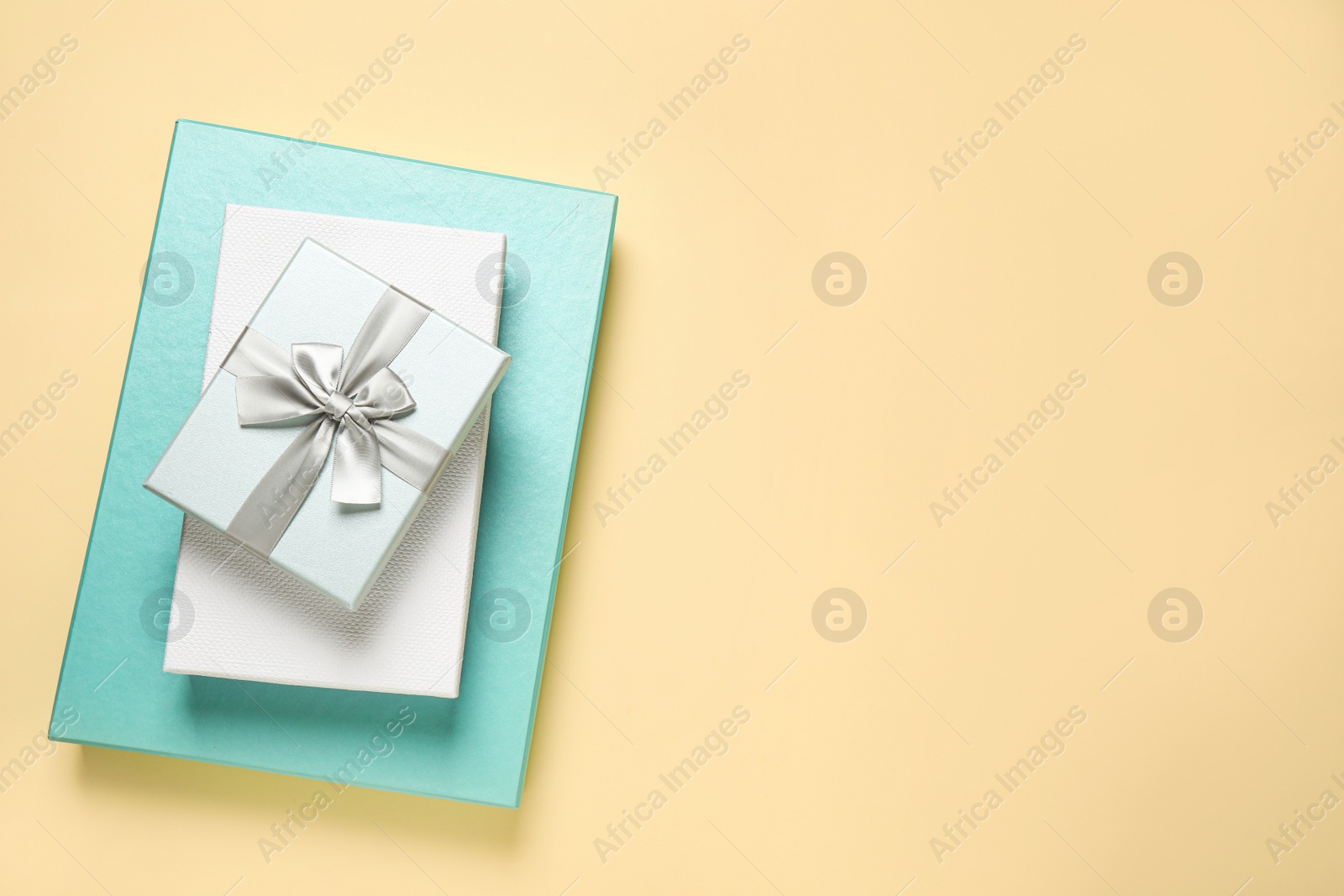 Photo of Beautiful gift boxes on beige background, top view. Space for text