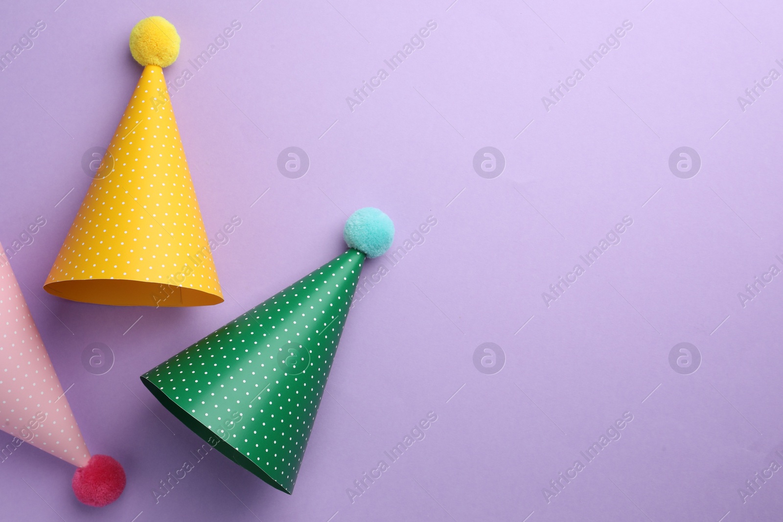 Photo of Beautiful party hats on purple background, top view. Space for text