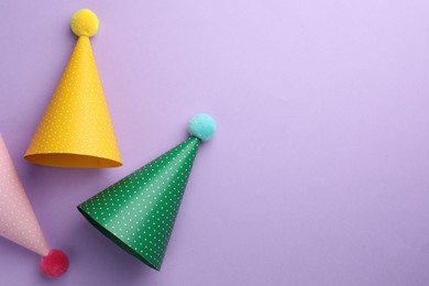 Photo of Beautiful party hats on purple background, top view. Space for text