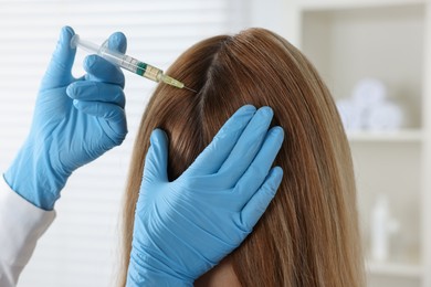 Photo of Trichologist giving injection to patient in clinic, closeup