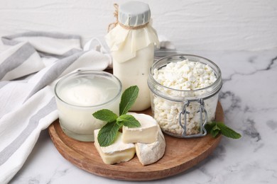 Photo of Different dairy products and mint on white marble table