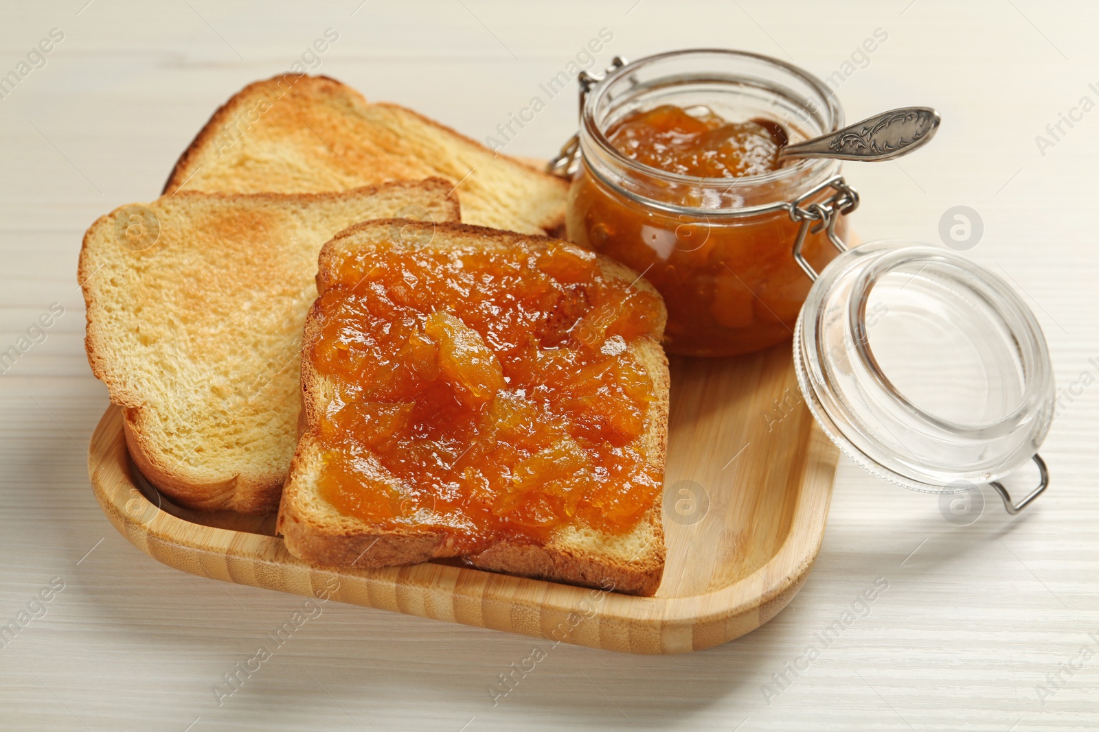 Photo of Delicious toasts with jam served on white wooden table, closeup