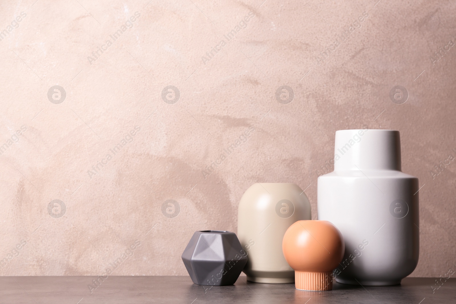 Photo of Stylish ceramic vases on grey stone table. Space for text