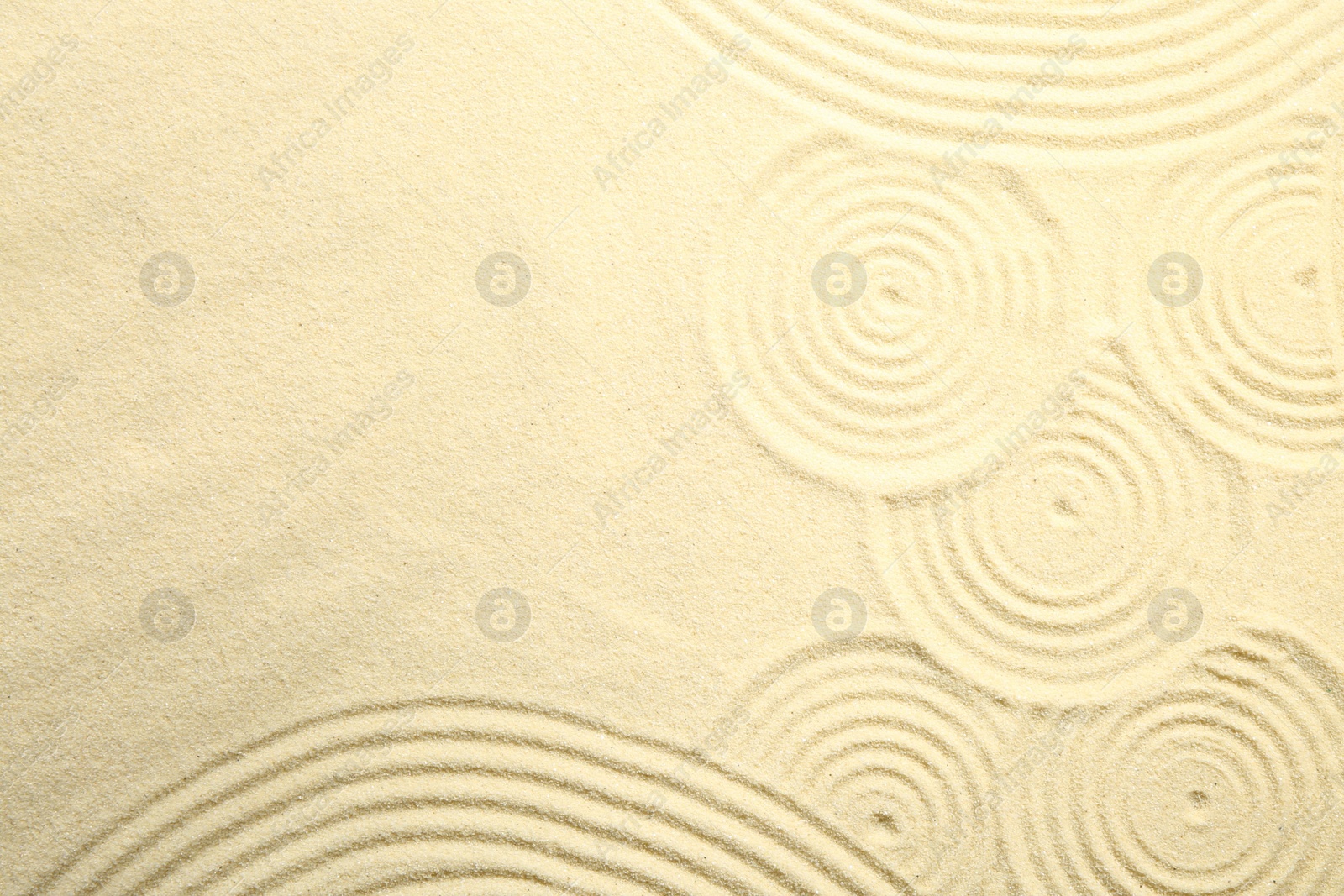 Photo of Zen rock garden. Circle patterns on beige sand, top view