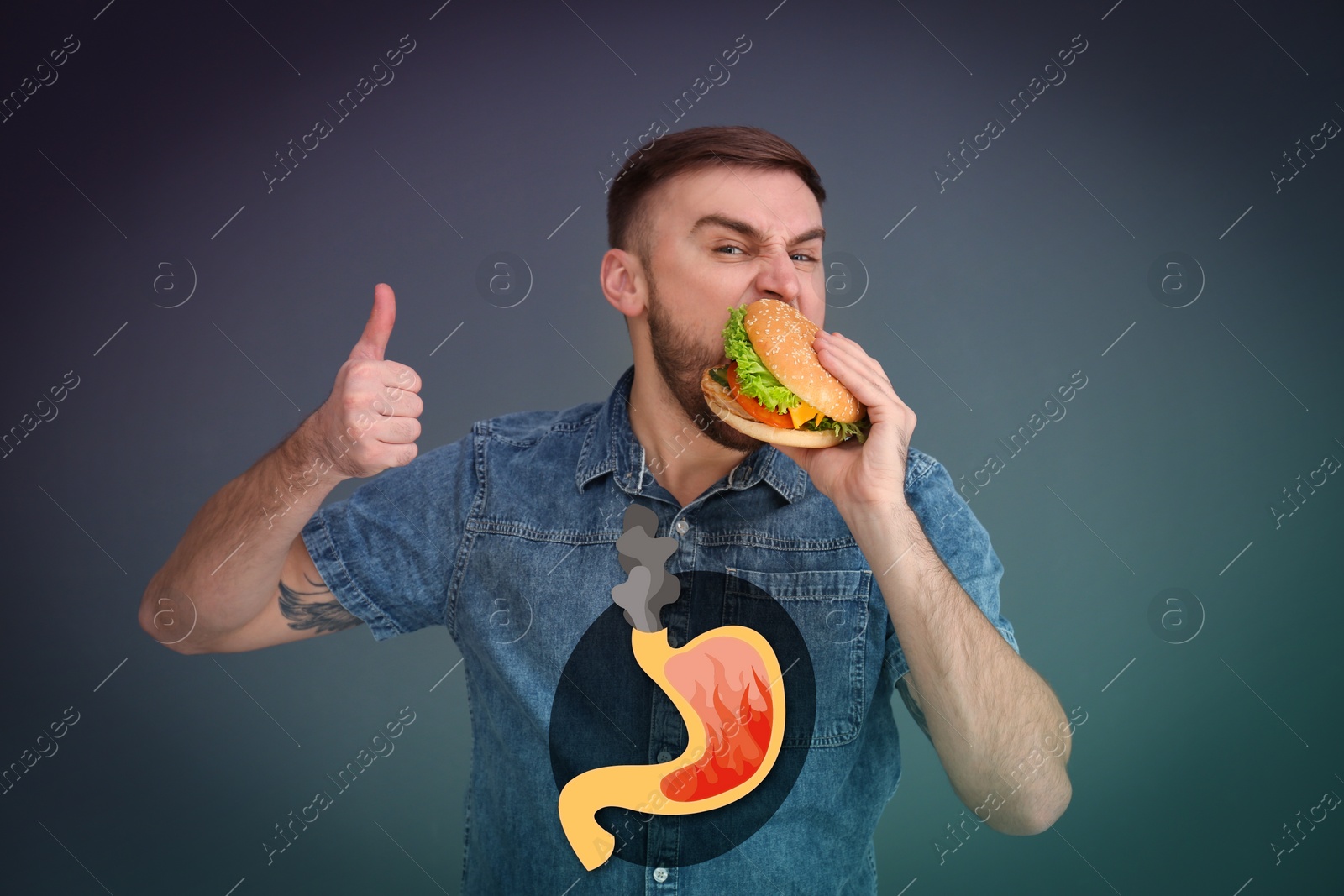 Image of Improper nutrition can lead to heartburn or other gastrointestinal problems. Happy man eating burger on dark background. Illustration of stomach with fire and smoke as acid indigestion