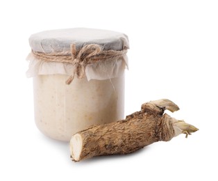Glass jar of tasty prepared horseradish and root isolated on white