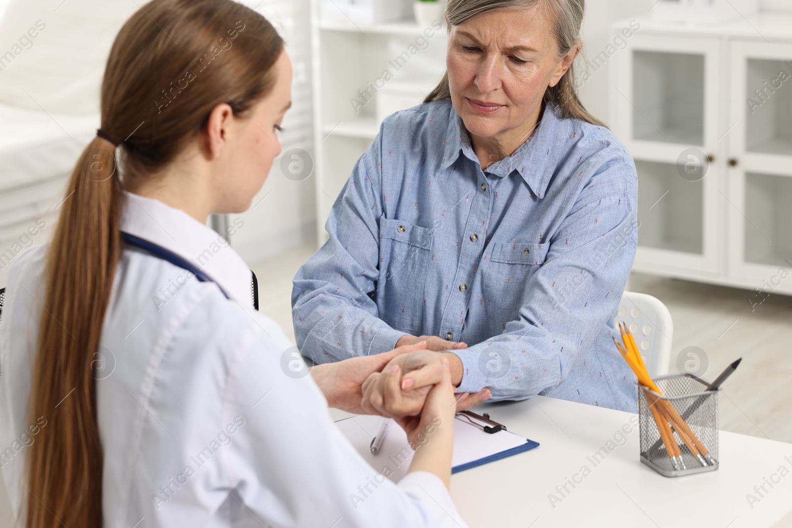 Photo of Arthritis symptoms. Doctor examining patient's wrist in hospital