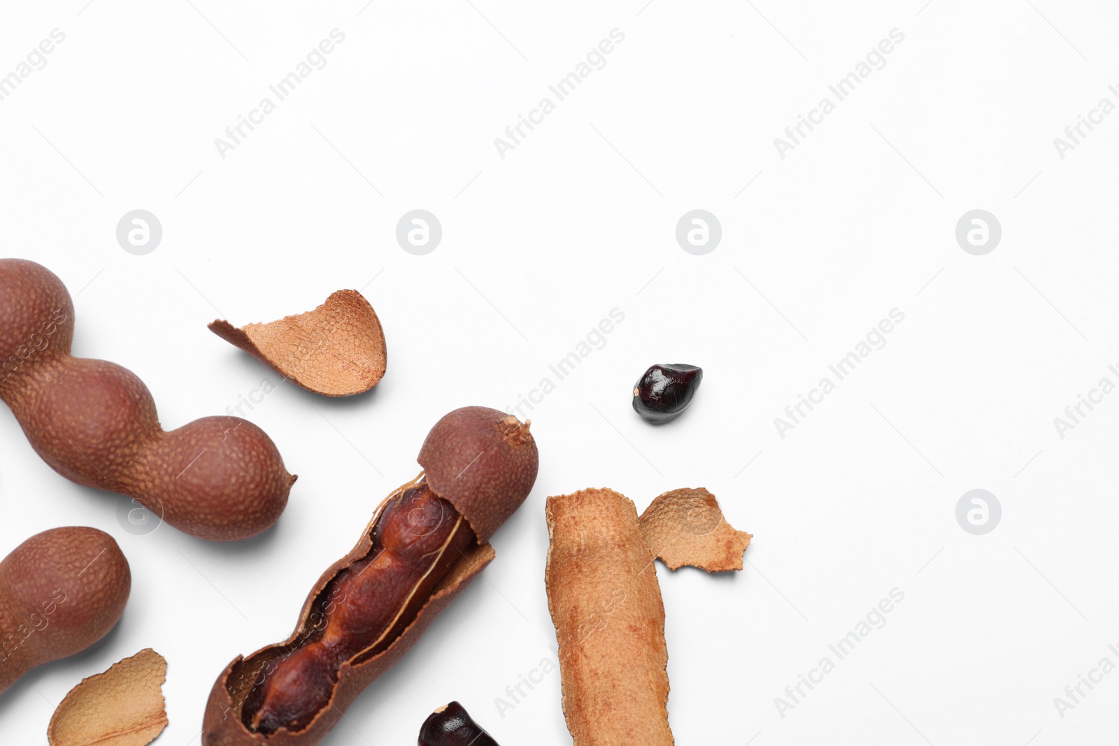 Photo of Ripe tamarinds on white background, flat lay. Space for text