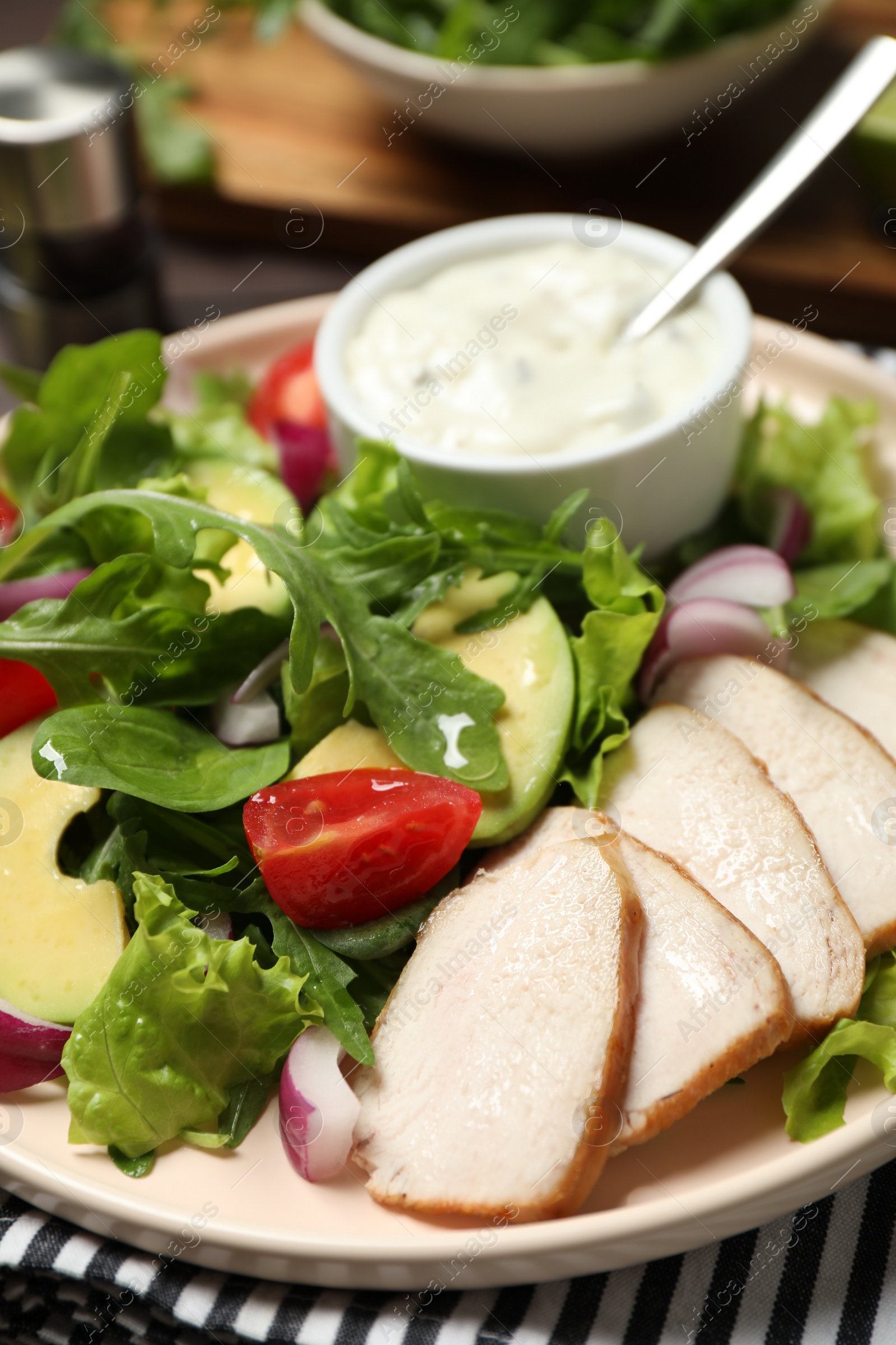 Photo of Delicious salad with chicken, arugula and avocado on plate, closeup