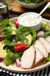 Photo of Delicious salad with chicken, arugula and avocado on plate, closeup