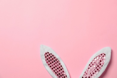 Photo of Funny Easter bunny ears on color background, top view with space for text