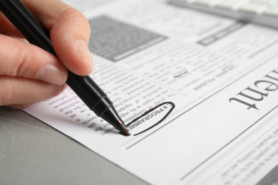 Woman marking advertisement in newspaper, closeup. Job search concept