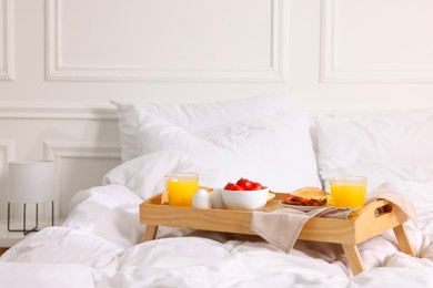 Photo of Good morning. Tray with tasty breakfast on bed at home. Space for text