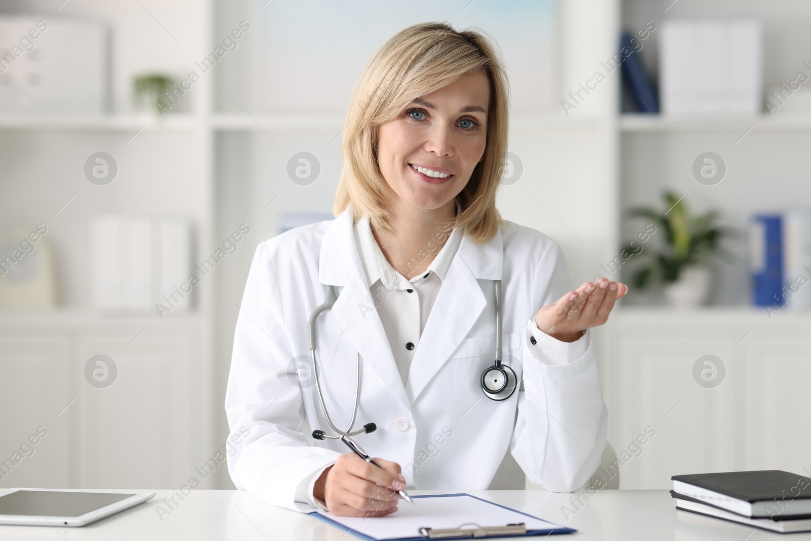 Photo of Portrait of smiling doctor at table in office