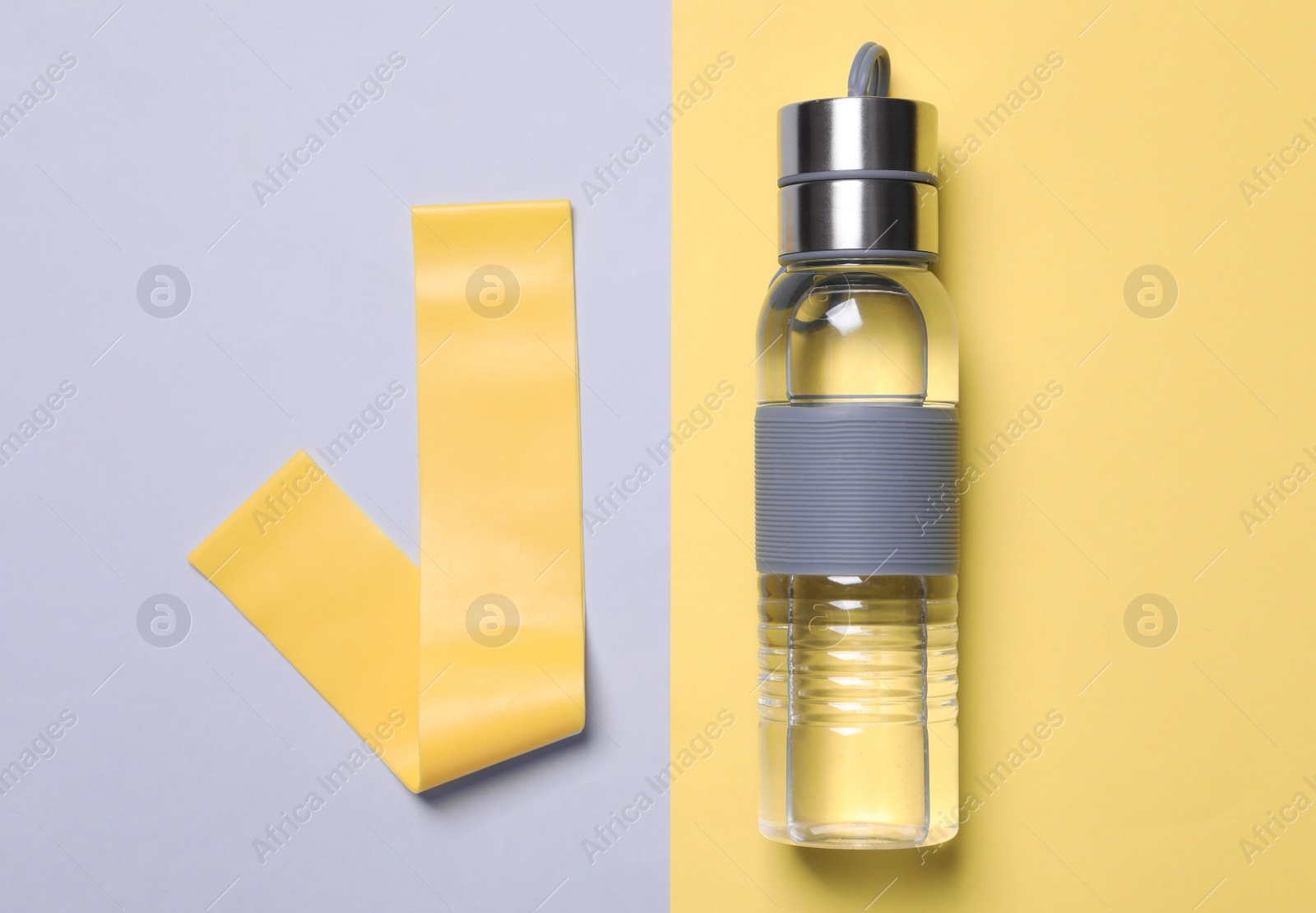 Photo of Fitness elastic band and bottle of water on color background, flat lay