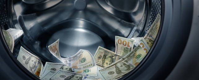 Image of Money laundering. Many dollar banknotes in washing machine, banner design