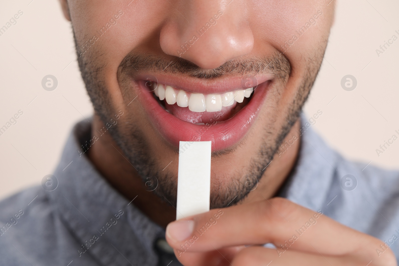 Photo of Man with chewing gum on blurred background, closeup