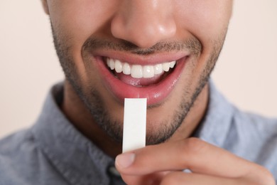 Man with chewing gum on blurred background, closeup