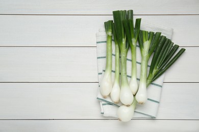 Photo of Whole green spring onions on white wooden table, flat lay. Space for text