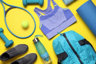 Photo of Flat lay composition with sports equipment on yellow background