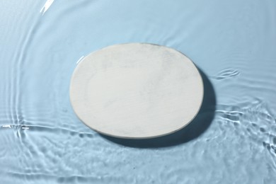 Photo of Presentation for product. White podium in water on light blue background, top view