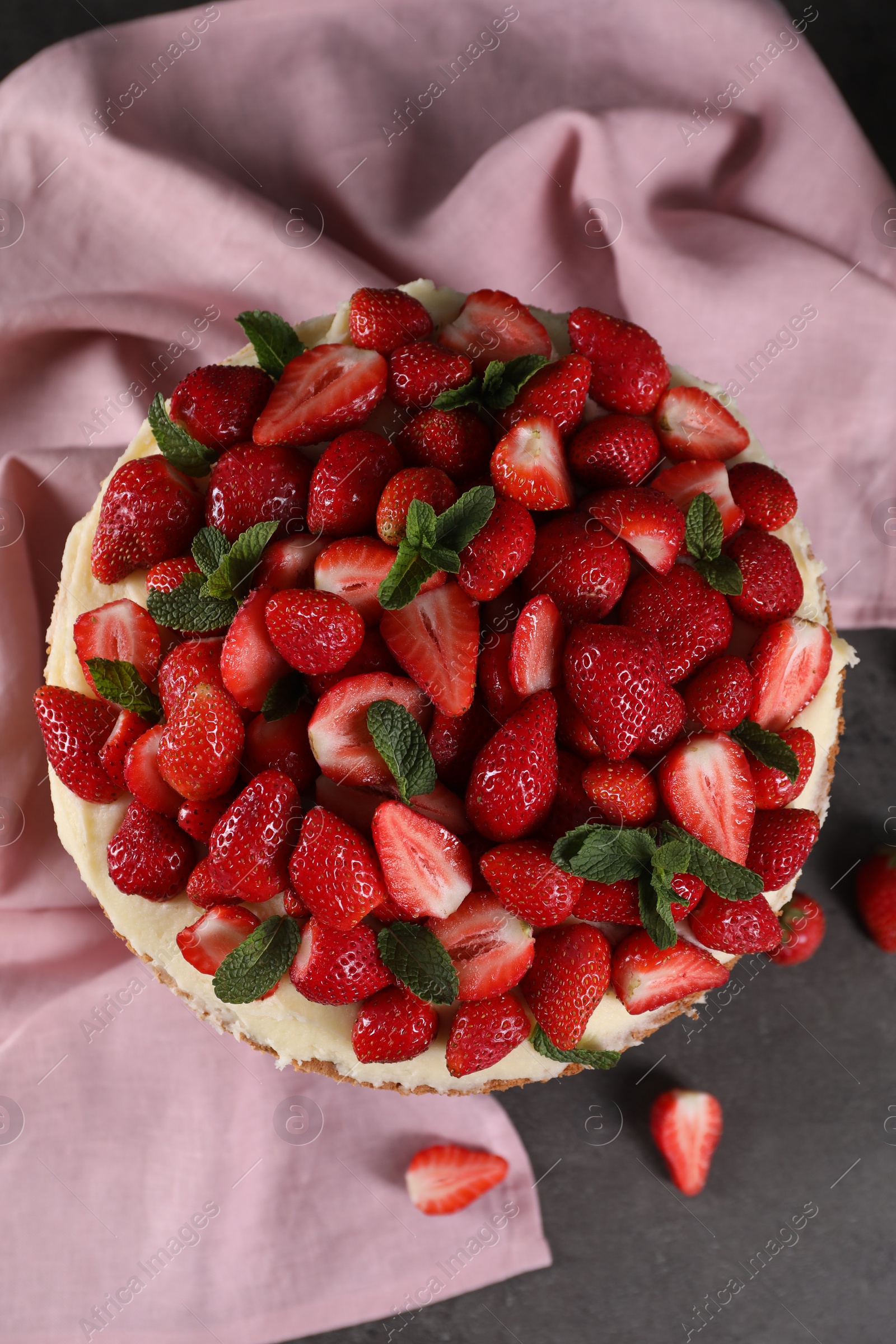 Photo of Tasty cake with fresh strawberries and mint on table, top view