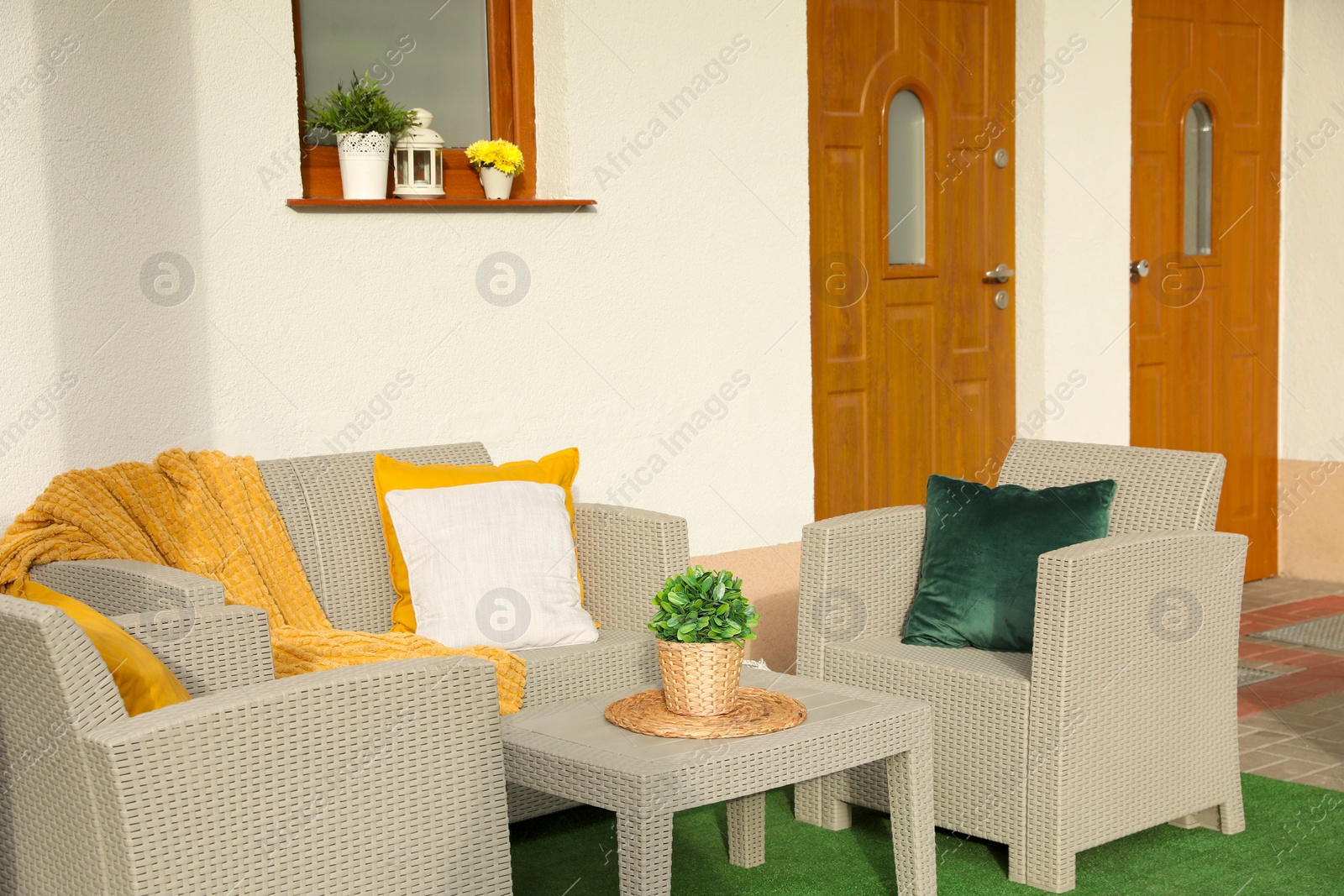 Photo of Beautiful rattan garden furniture, soft pillows, blanket and houseplant outdoors