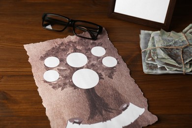 Photo of Paper with family tree template, photos and glasses on wooden table