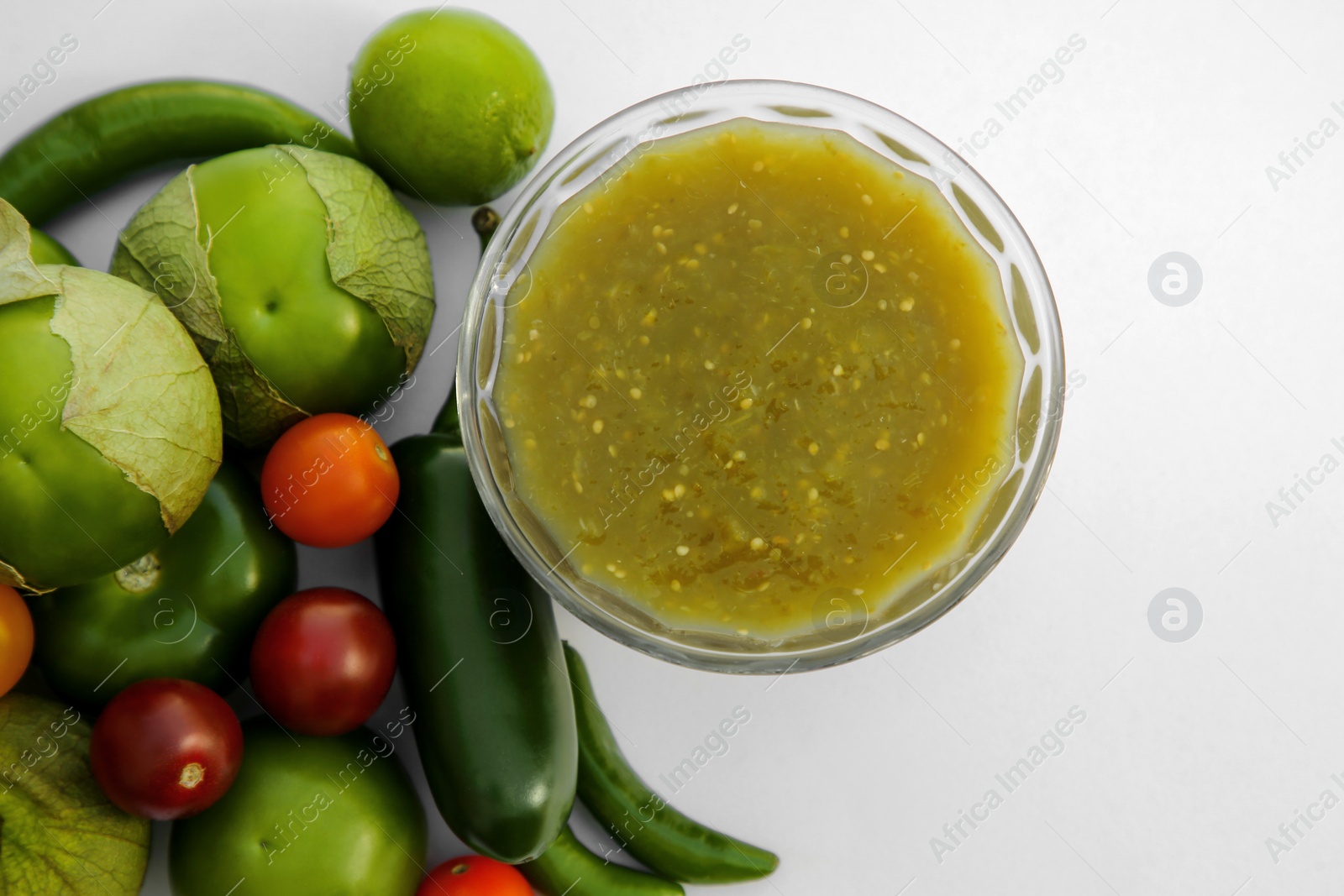 Photo of Bowl with delicious salsa sauce and ingredients on white background, flat lay