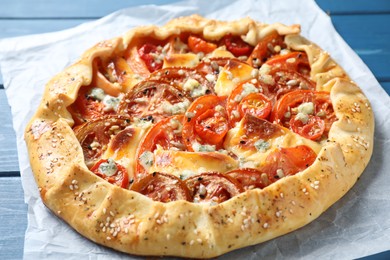 Tasty galette with tomato and cheese (Caprese galette) on blue wooden table, closeup