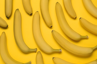 Ripe sweet bananas on yellow background, flat lay