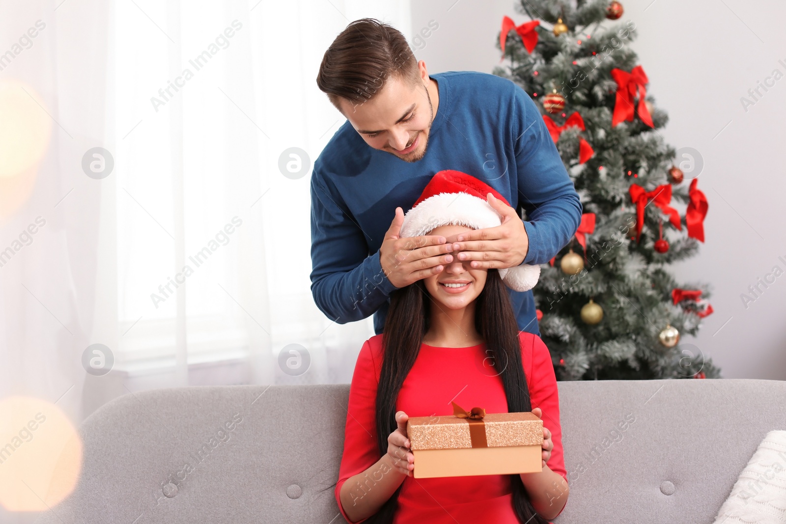 Photo of Happy young couple celebrating Christmas at home