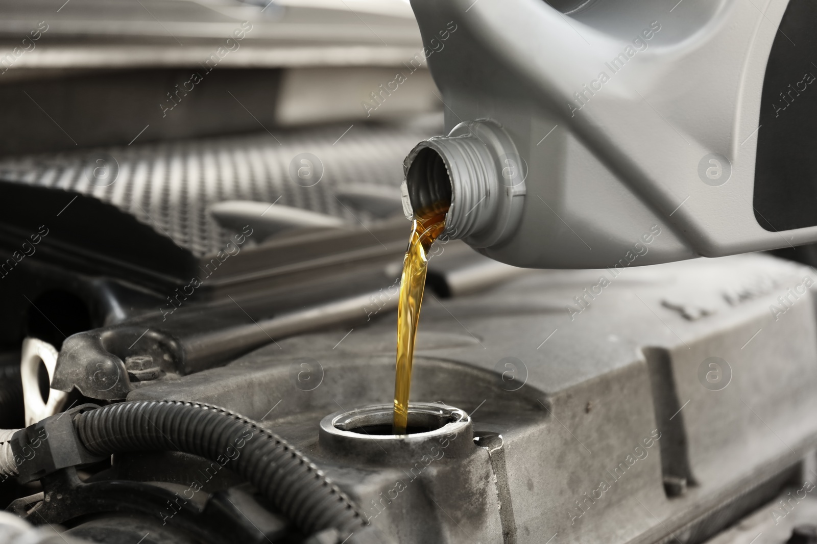 Photo of Pouring oil into car engine, closeup