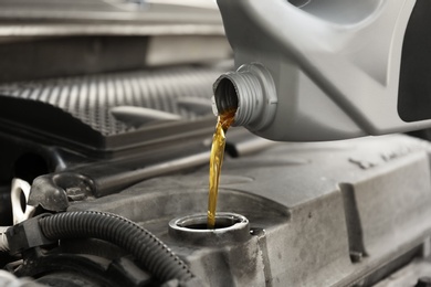 Pouring oil into car engine, closeup