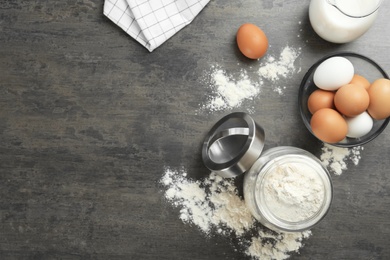 Photo of Jar with flour and eggs on grey background