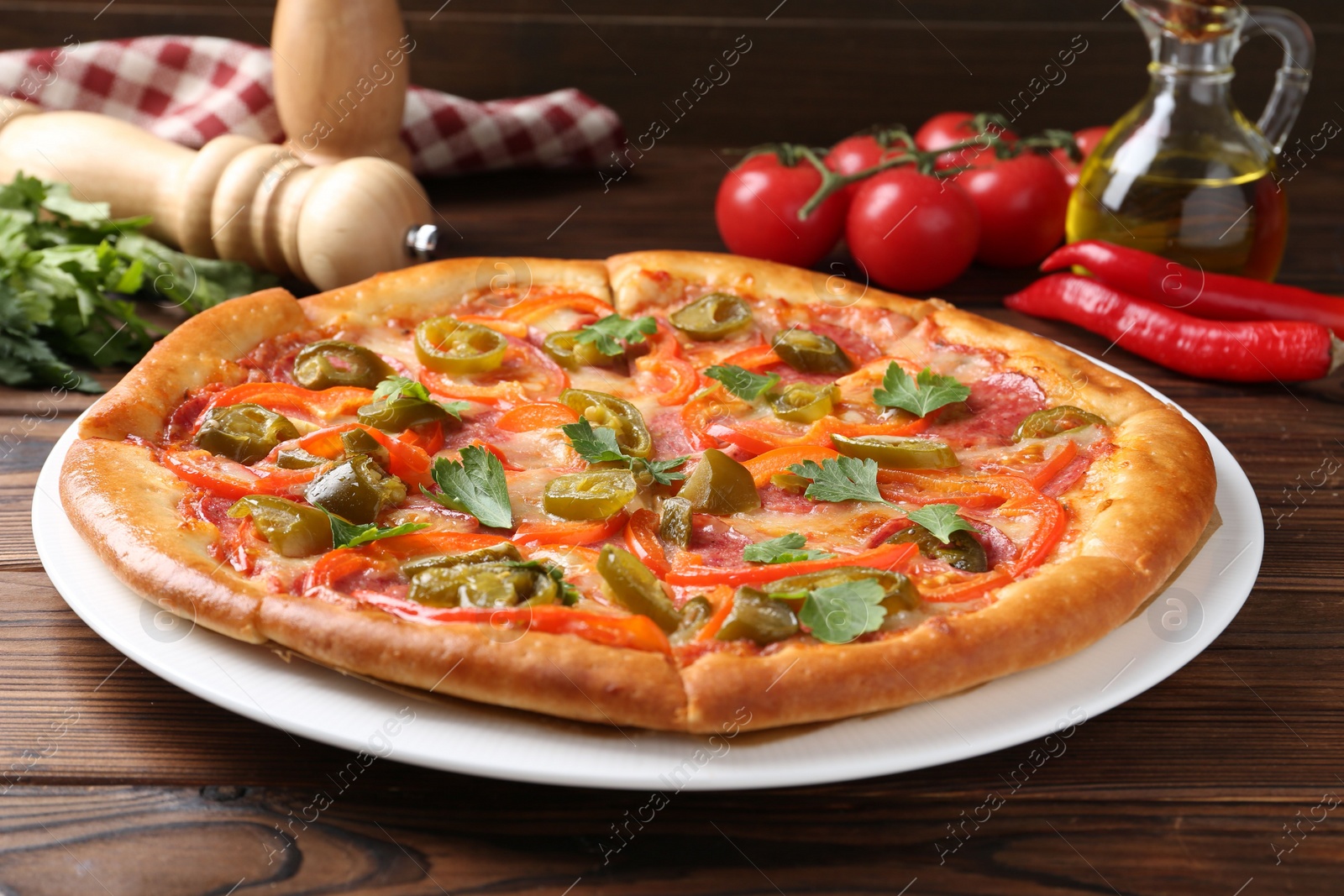 Photo of Delicious pizza Diablo and ingredients on wooden table, closeup