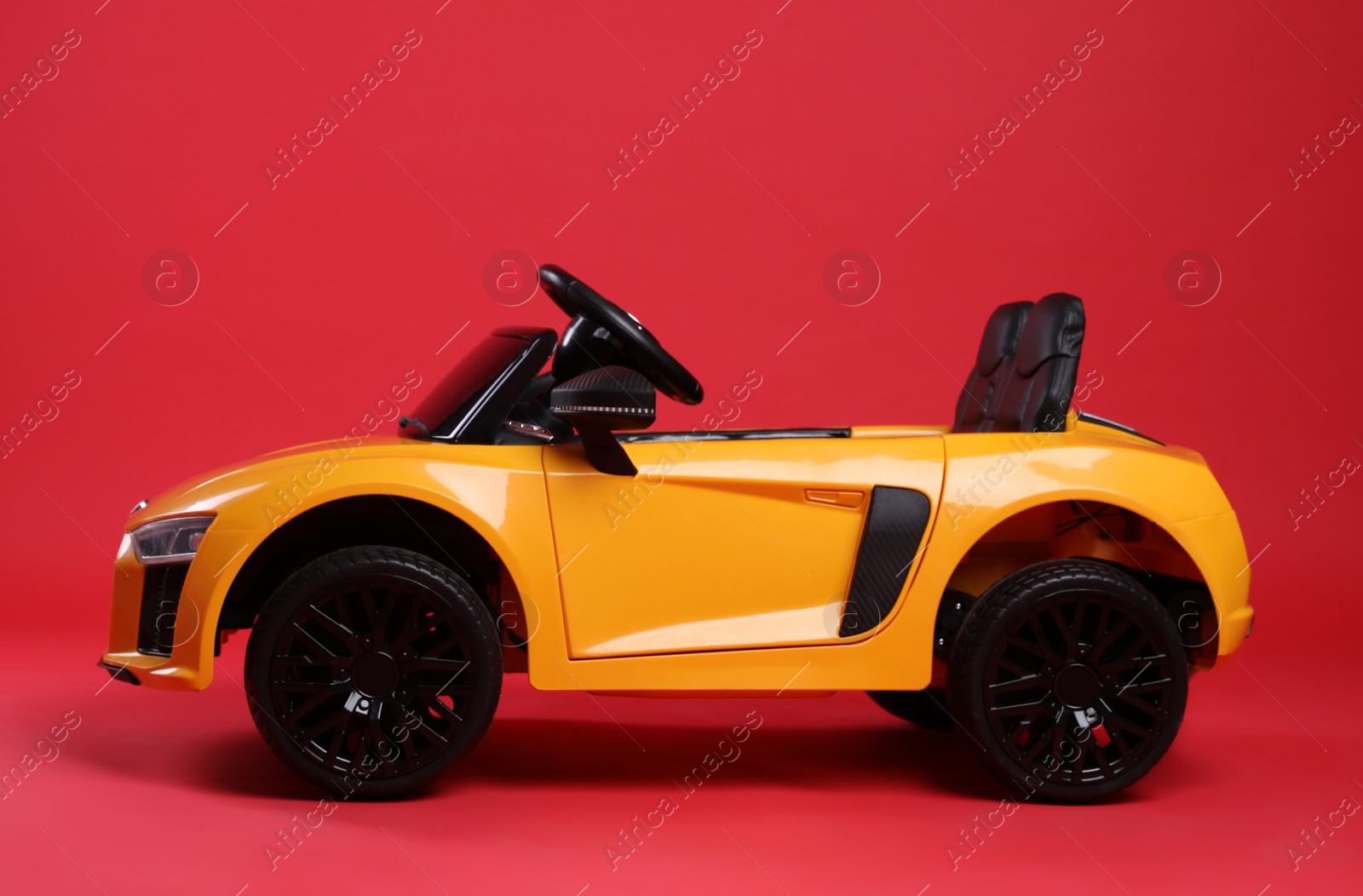 Photo of Child's electric toy car on red background