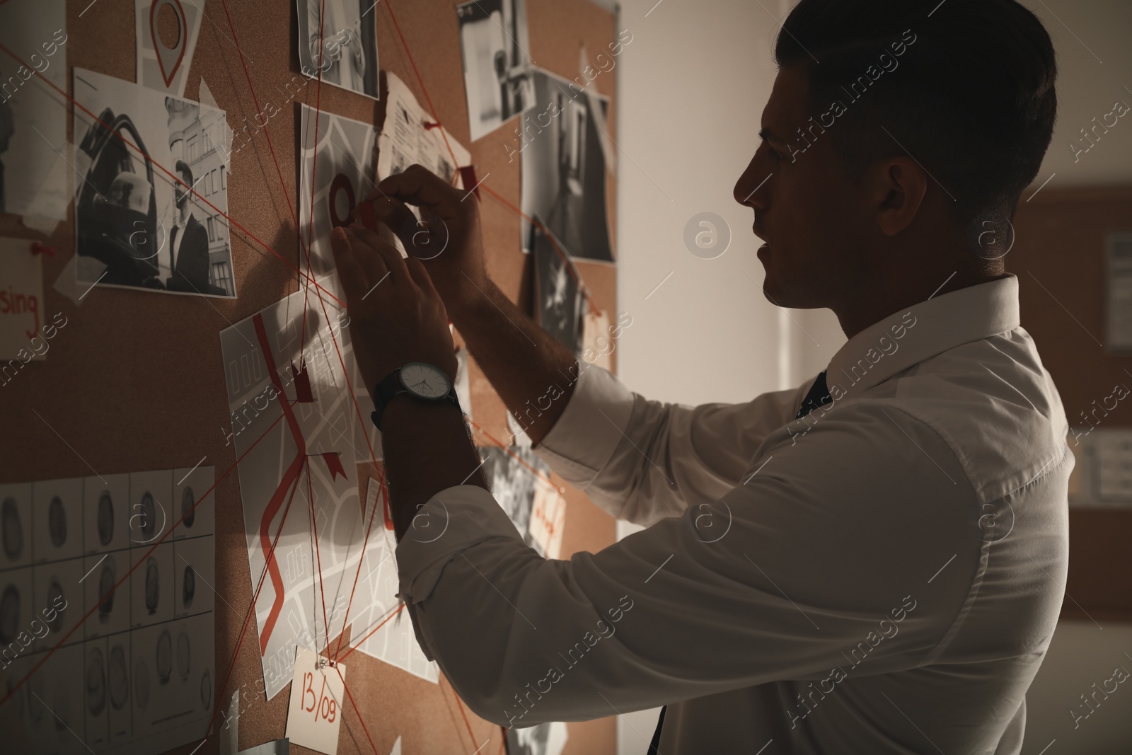 Photo of Detective looking at evidence board in office