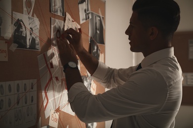 Photo of Detective looking at evidence board in office