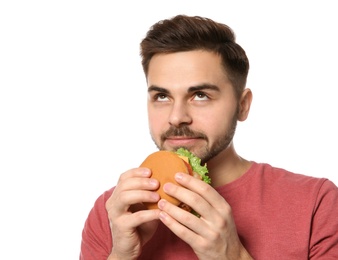 Handsome man eating tasty burger isolated on white