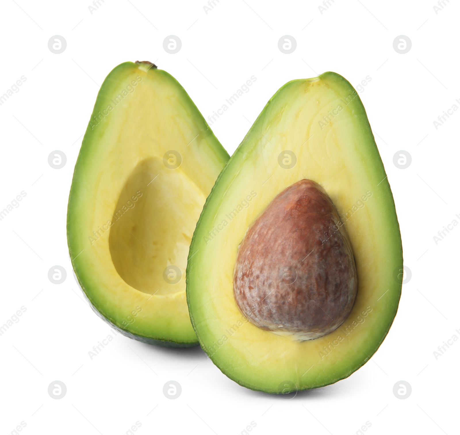 Photo of Halves of ripe avocado with pit on white background