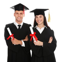 Happy students in academic dresses with diplomas on white background