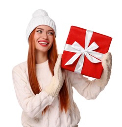 Young woman in hat and sweater with Christmas gift on white background