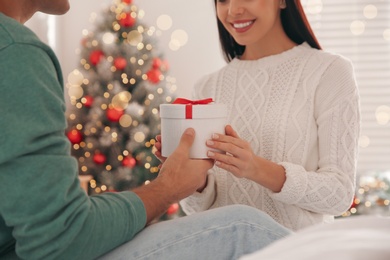 Photo of Happy couple with gift in bed, closeup. Christmas celebration
