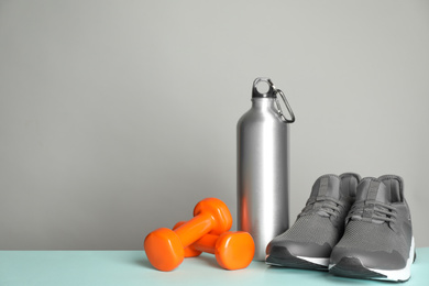 Photo of Composition with fitness equipment on light table, space for text