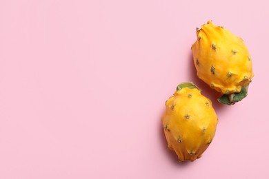 Photo of Delicious yellow pitahaya fruits on light pink background, flat lay. Space for text