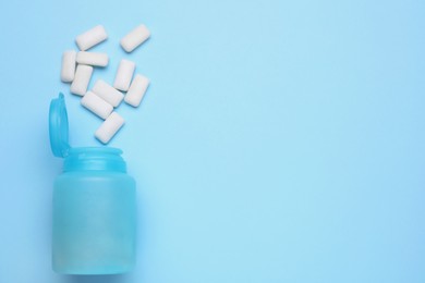 Photo of Jar with chewing gums on light blue background, flat lay. Space for text