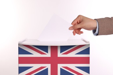 Woman putting her vote into ballot box decorated with flag of United Kingdom against white background, closeup