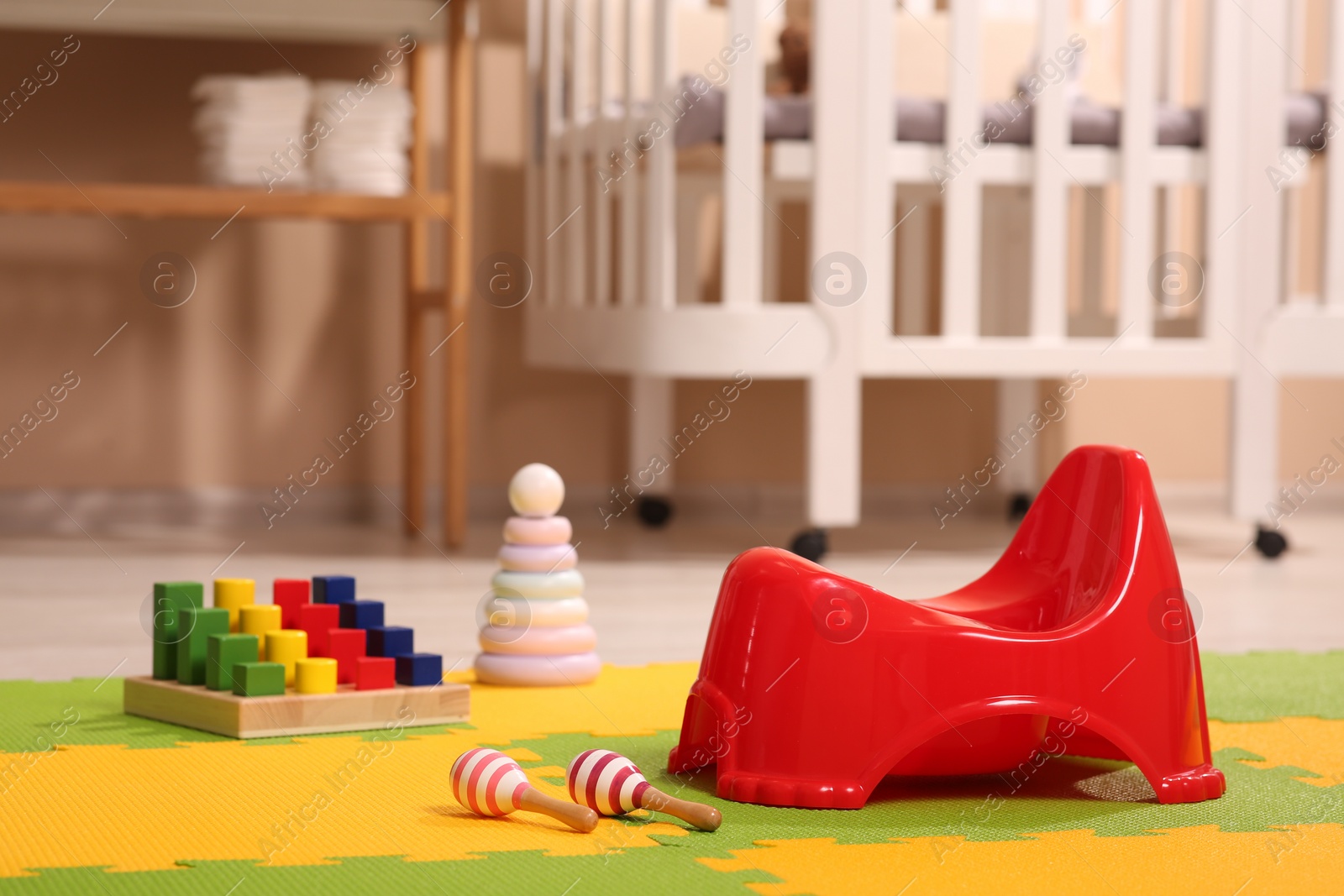 Photo of Red baby potty and maracas in room. Toilet training